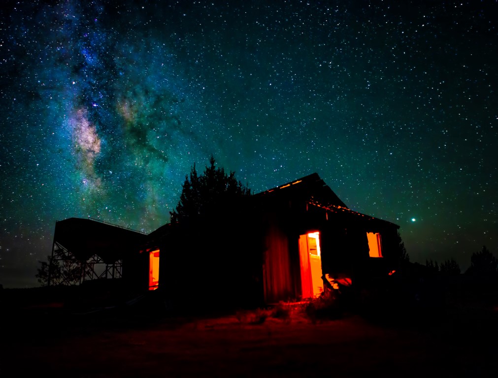 A wide angle view of the Milky Way as it rises over an abandoned home near Kenton Okalhoma