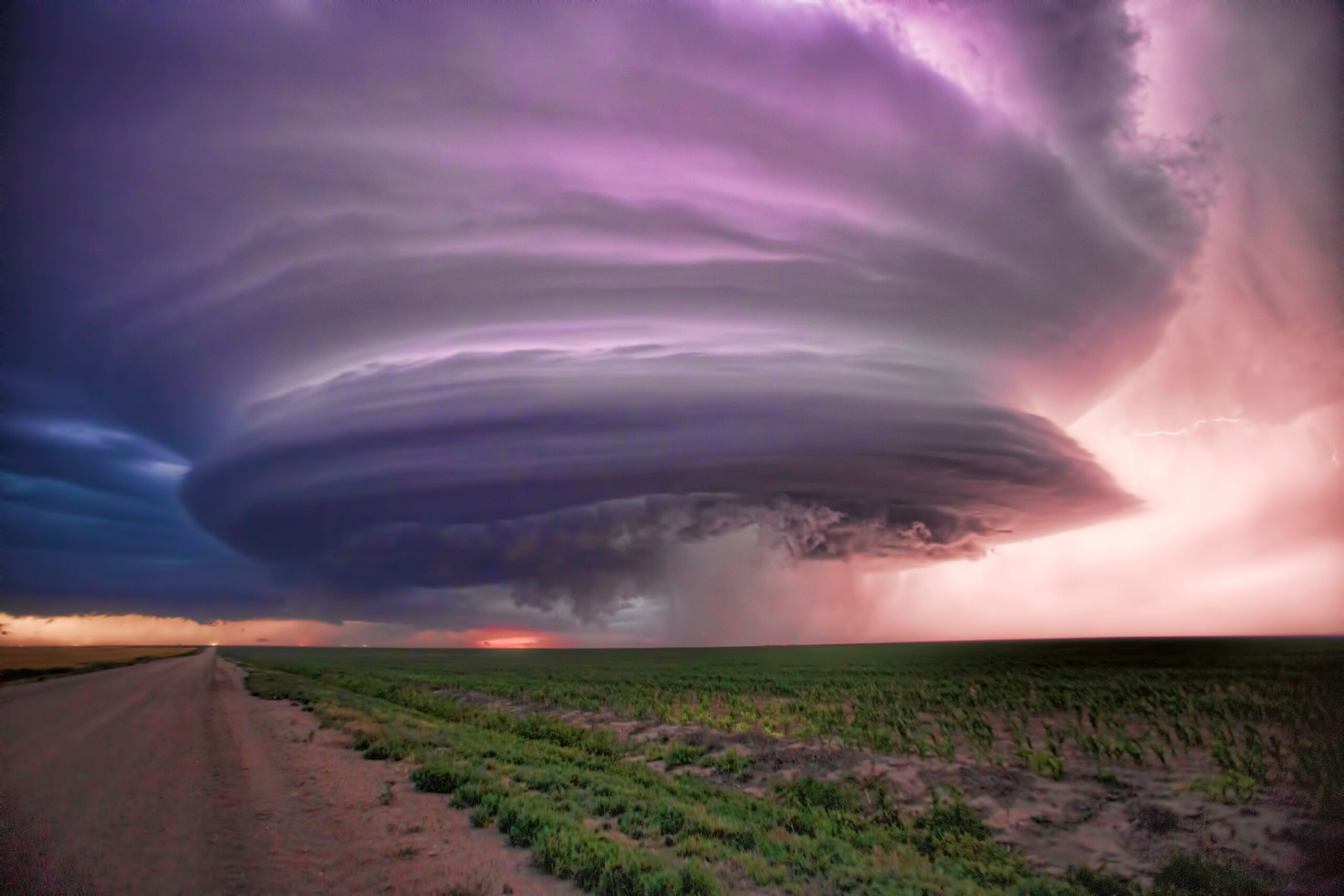 A supercell thunderstorm hovers over a newly planted corn field in Wichita County Kansas