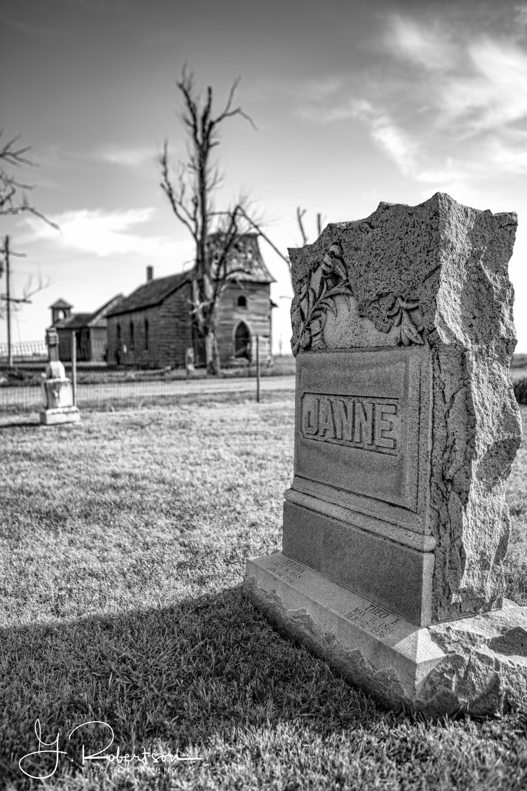 A family headstone lies in front of an abandoned church near Dubuque Kansas.