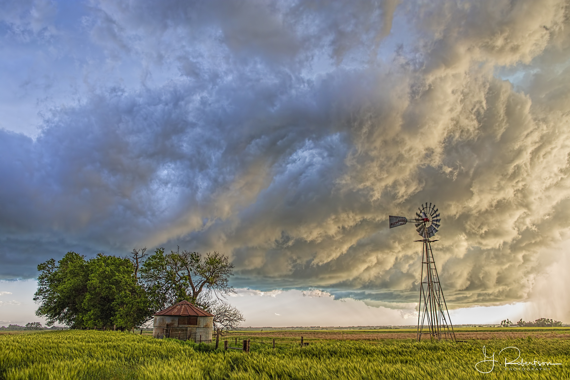 The back side of a gust front passes over a grain silo and windmill in Major County Oklahoma