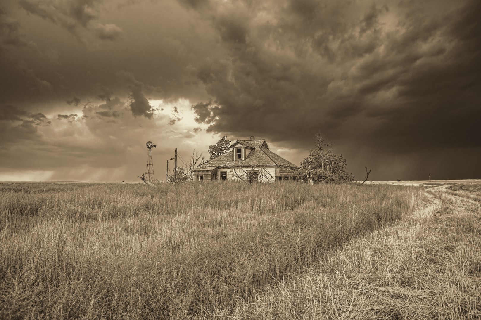 A thunderstorm passes an abandoned farmstead in northern Hodgeman County Kansas